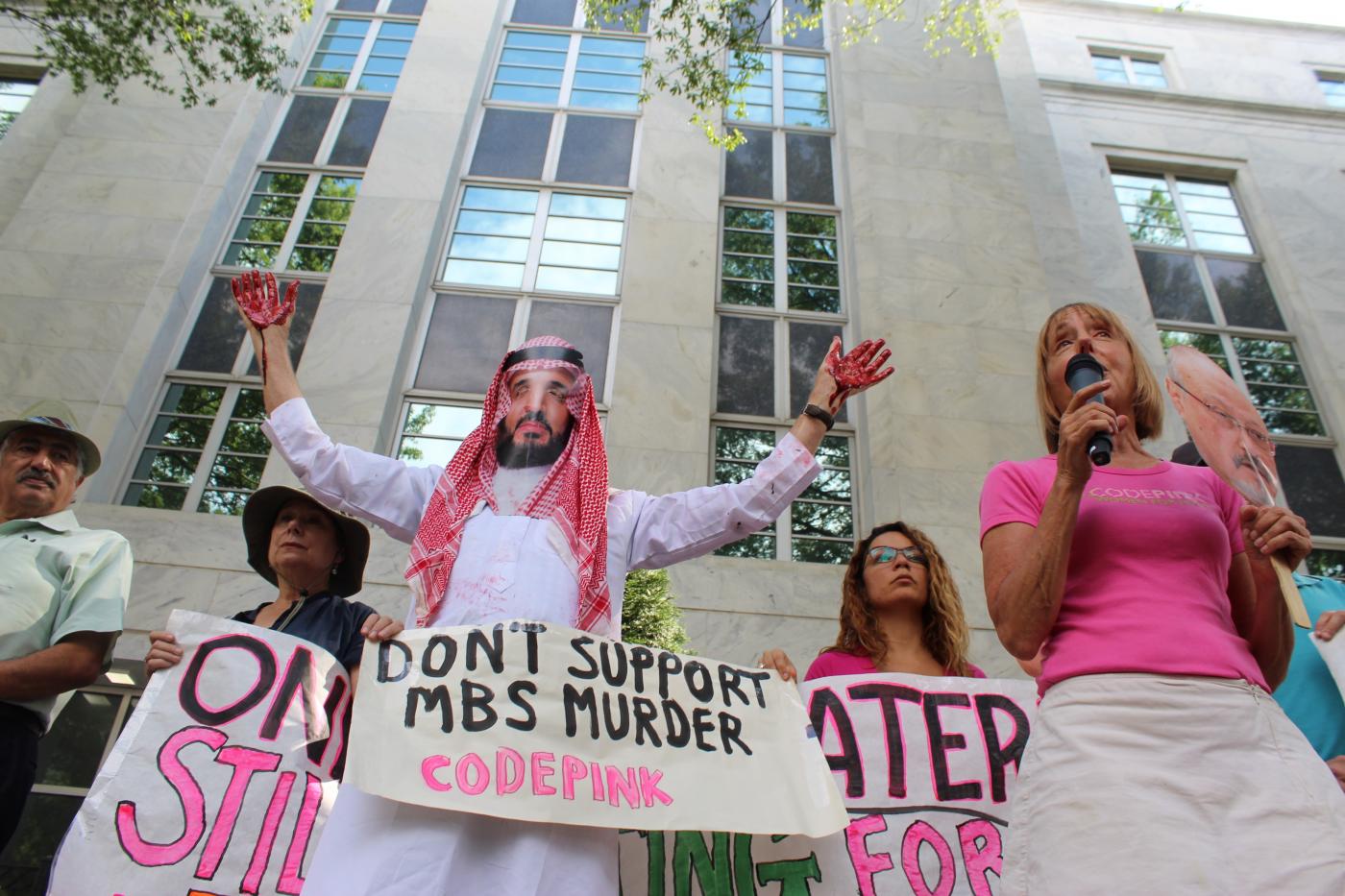 متظاهر يرتدي زي محمد بن سلمان ويضع قناعًأ يشبهه ويرفع يده الملطخة "بالدم" خارج السفارة السعودية في العاصمة واشنطن